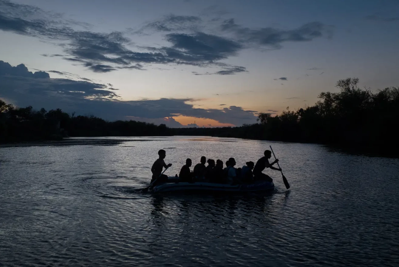 Smugglers use a raft to transport migrants from Mexico across the Rio Grande into the United States, in Roma, on Aug. 26, 2022.